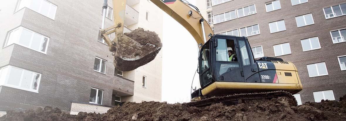 Cat 320D Excavator lifting dirt