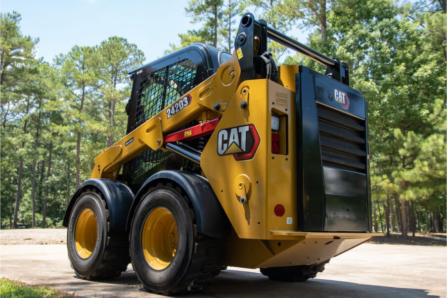 A clean Cat 242D3 Skidsteer parked in front on a greenspace